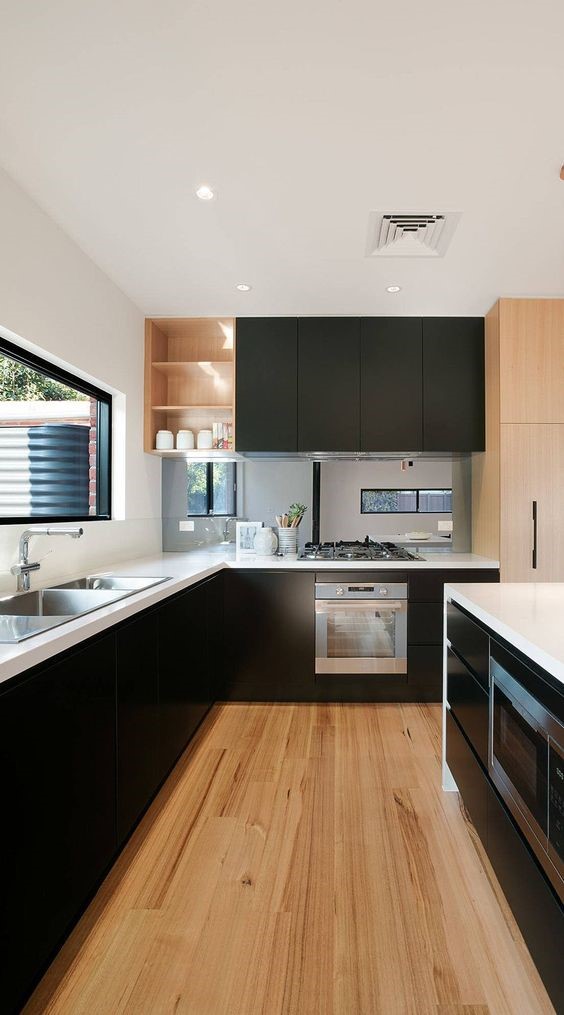 Black and white modular kitchen with wooden flooring